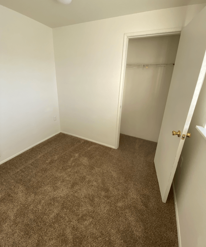 an empty room with a closet and a door