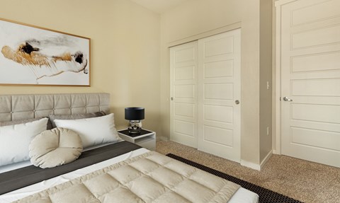 A bedroom with a bed, a lamp, and a painting on the wall.