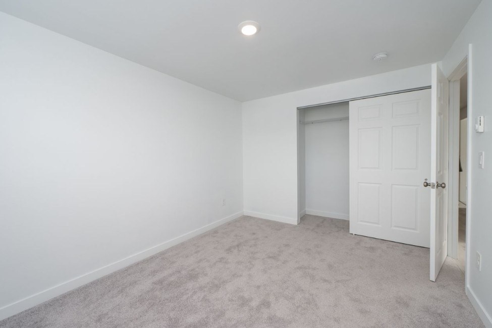 A room with a carpeted floor and a white door.
