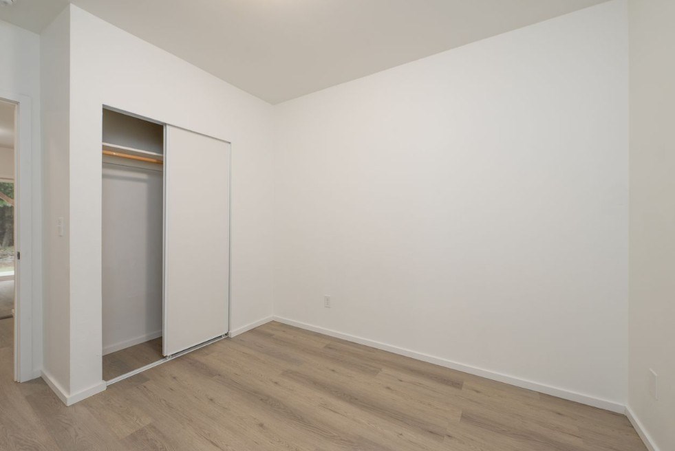A room with a white wall and a wooden floor.