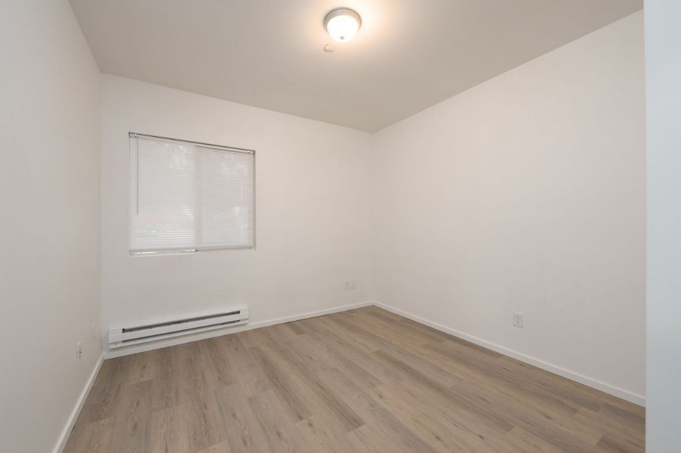 A room with a window and a radiator on the wall.