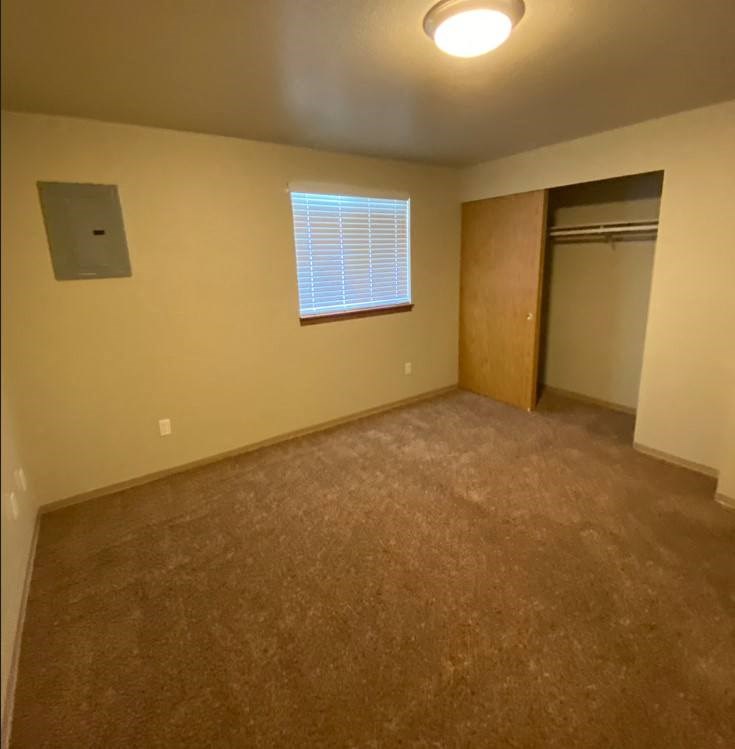 an empty room with a closet and a window