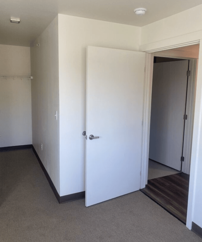 an empty room with a closet and a door