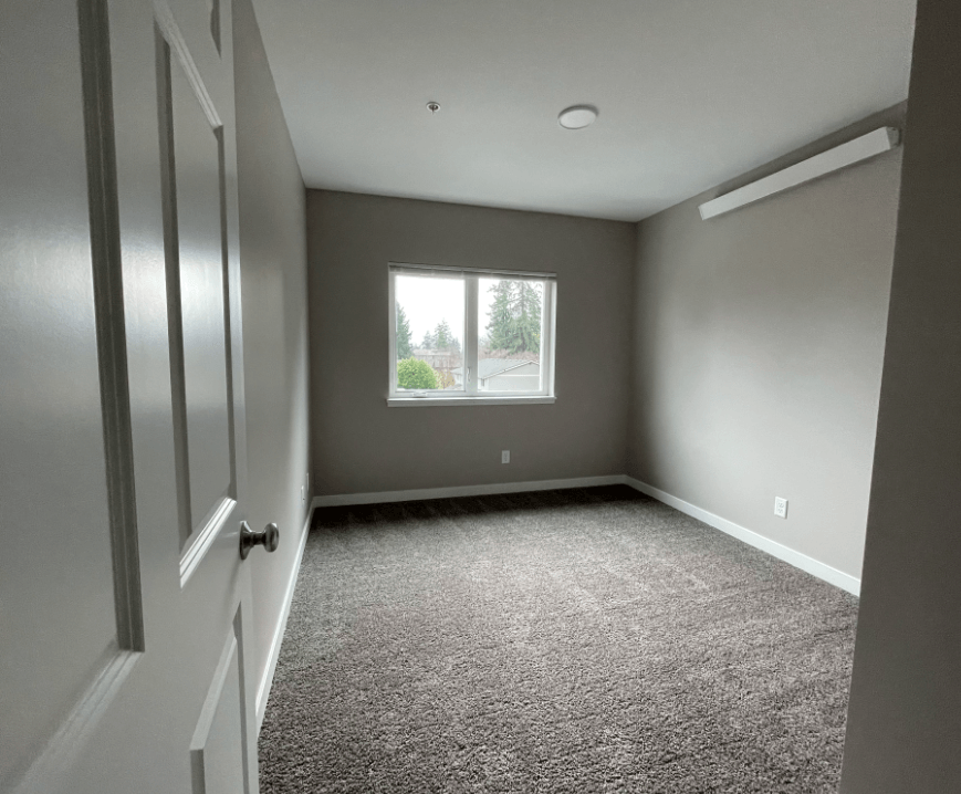 an empty room with a window and a door