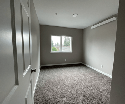 an empty room with a window and a door