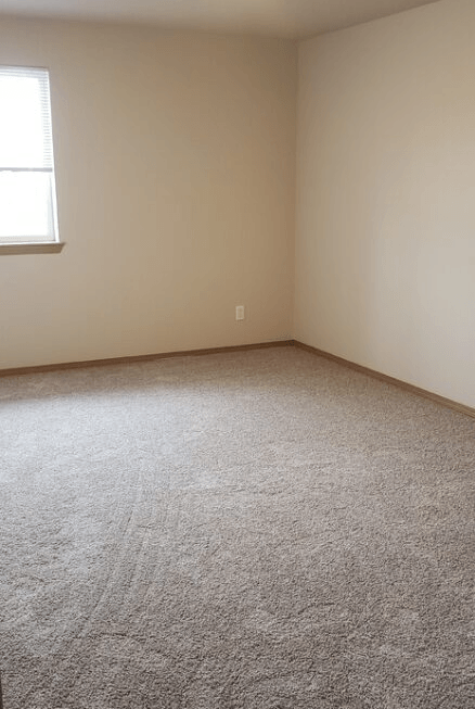 a room with a carpeted floor and a window
