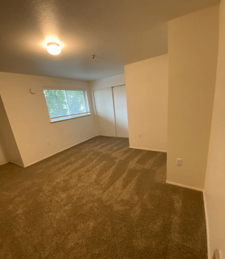 the living room of an empty house with a window