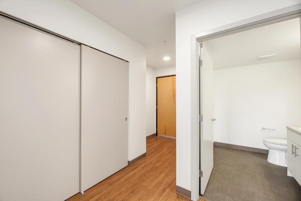 a bedroom with a door to a bathroom and a closet