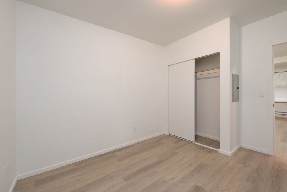 A room with a white wall and a wooden floor.