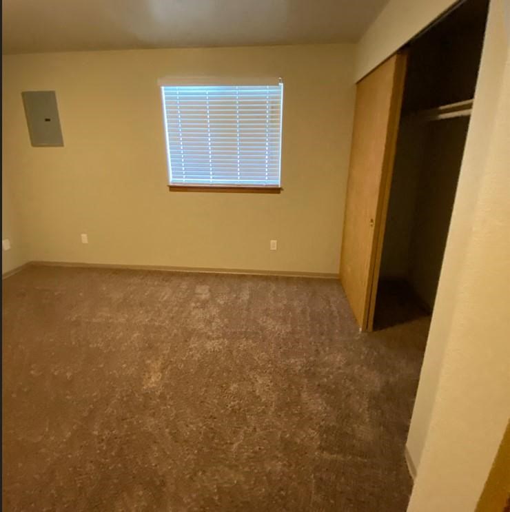 an empty room with a window and a closet