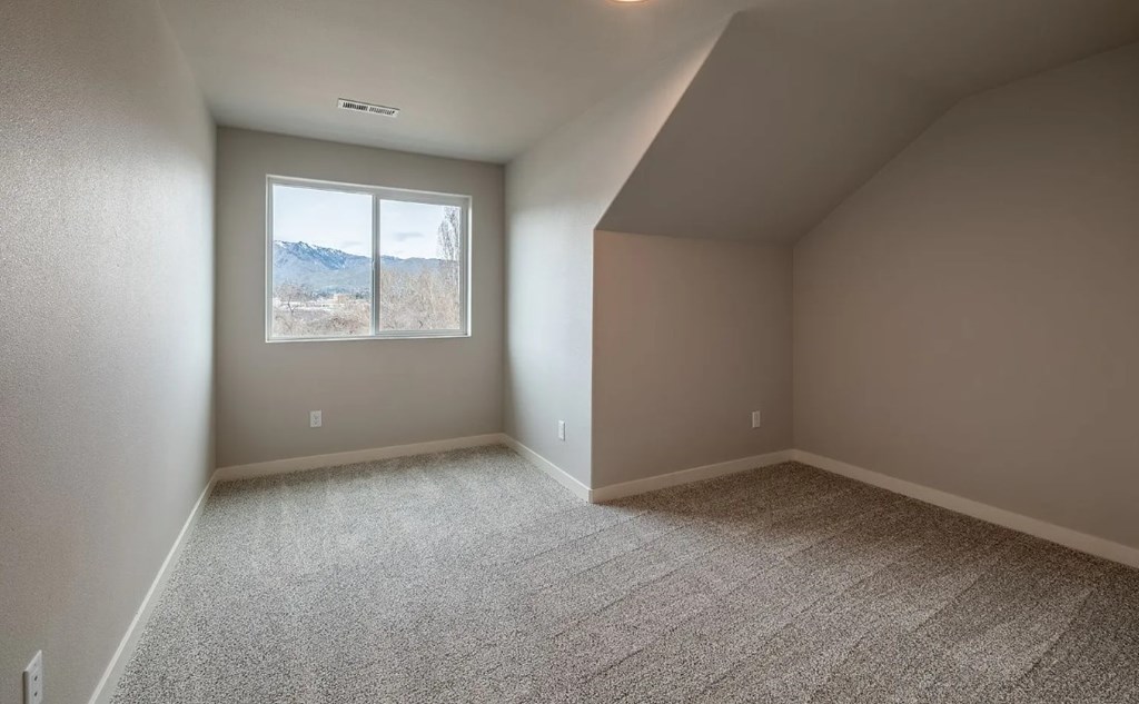 A room with a window showing a mountain view.