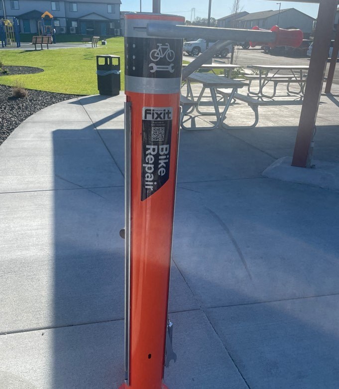 a pole with a sticker on it on a sidewalk