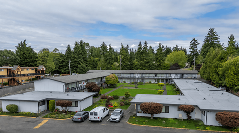 A large white building with a parking lot in front of it.