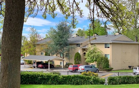 a large apartment building with cars parked in a parking lot