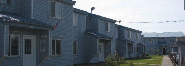 a row of blue houses next to a sidewalk