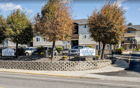 a yard with signs in front of an apartment building