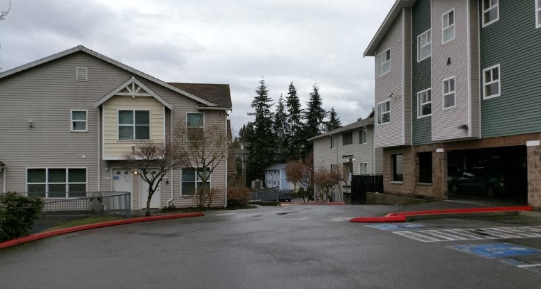A parking lot in front of apartment buildings.