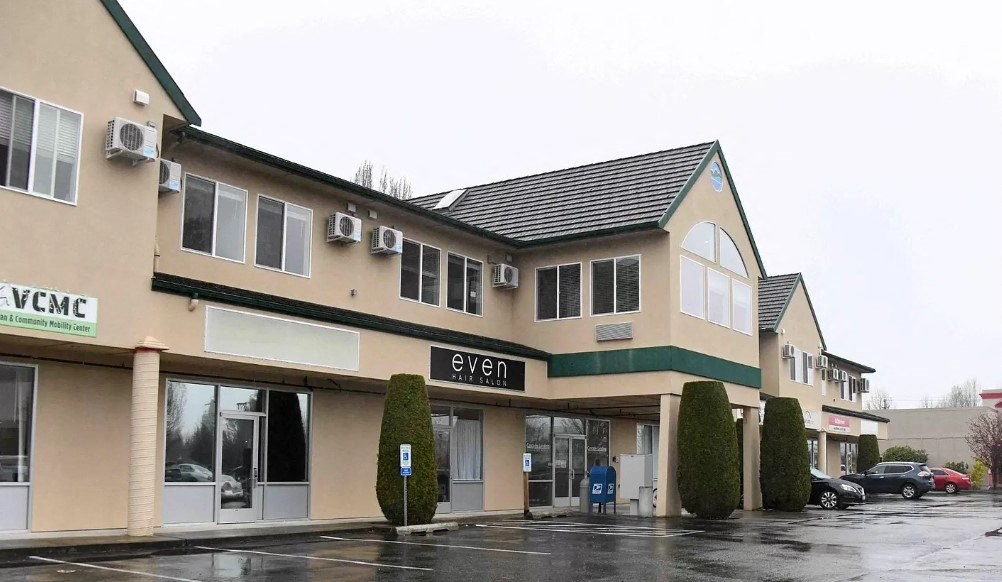 the front of a building with a parking lot