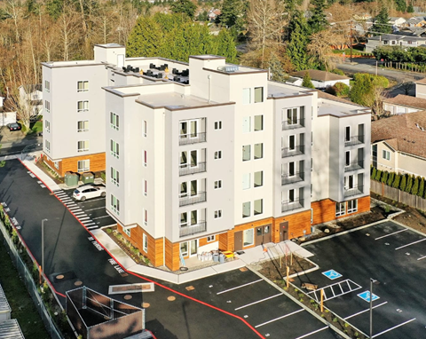 A large white building with a red line in the parking lot.