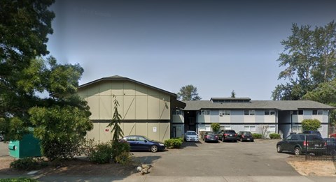 A parking lot with cars and a building in the background.