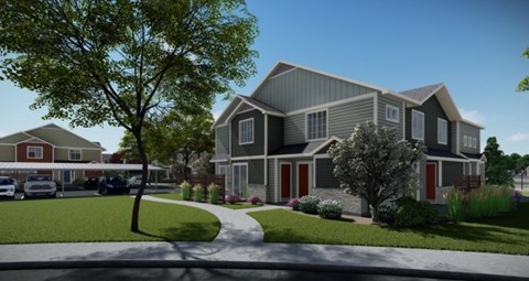 A modern house with a grey exterior and red shutters is surrounded by greenery.