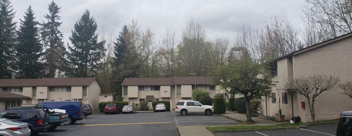 a parking lot with cars in front of an apartment building