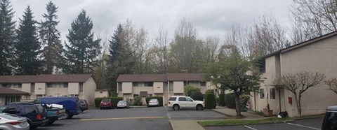 a parking lot with cars in front of an apartment building