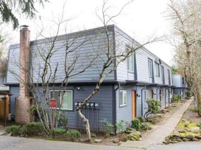 A blue house with a red sign in front of it.