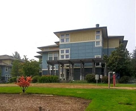 a blue building with a lawn in front of it