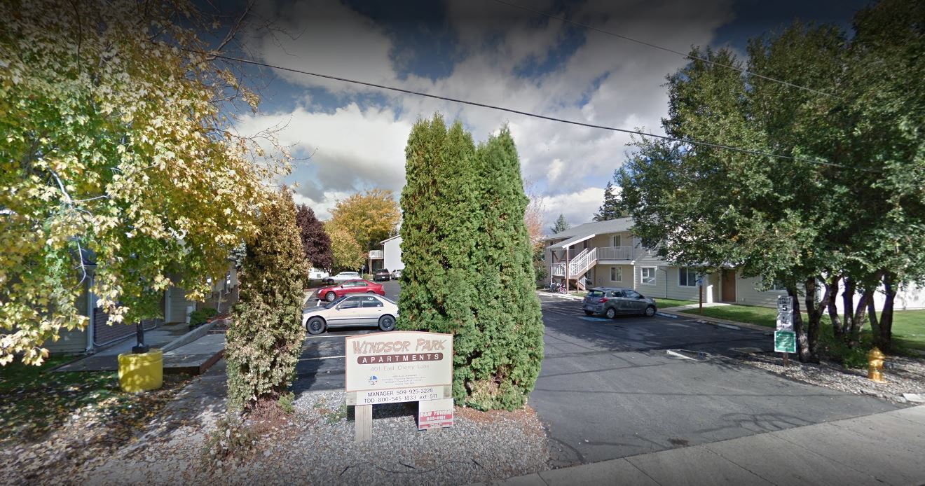 a street with cars parked in front of a sign