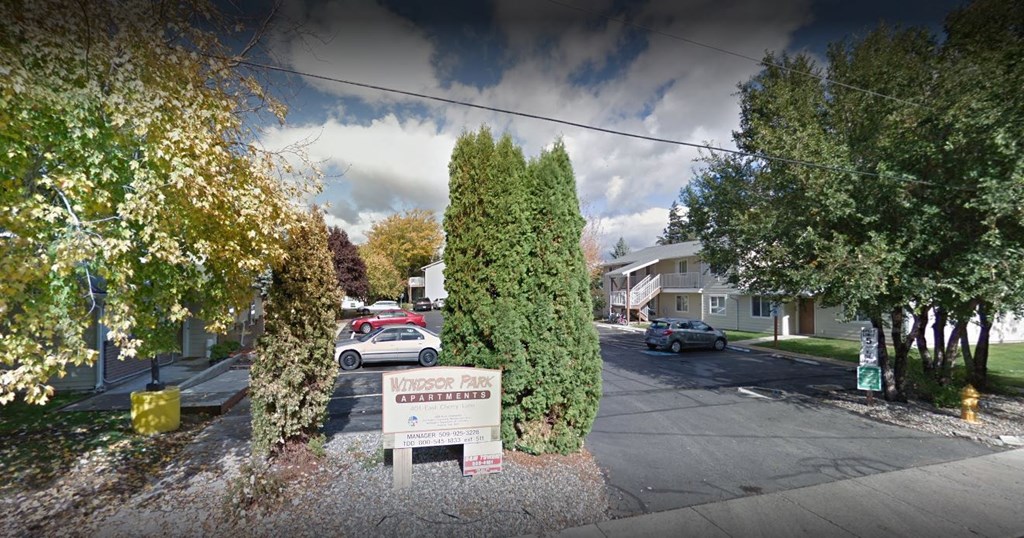 a street with cars parked in front of a sign