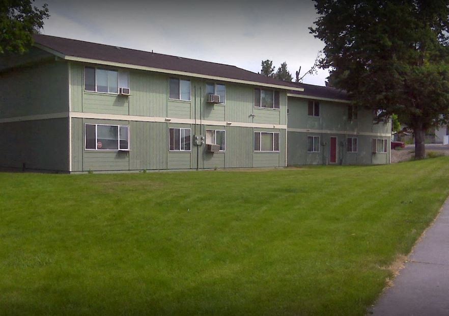 a green building with a lawn in front of it