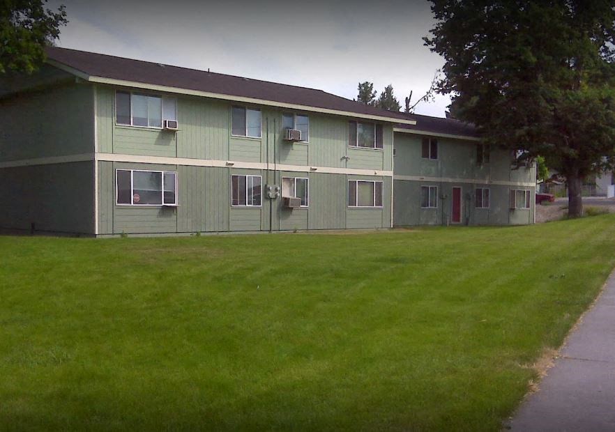 a green building with a lawn in front of it