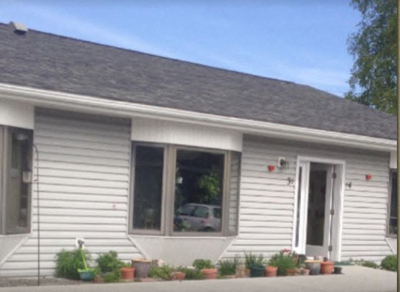 the front of a white house with a large window