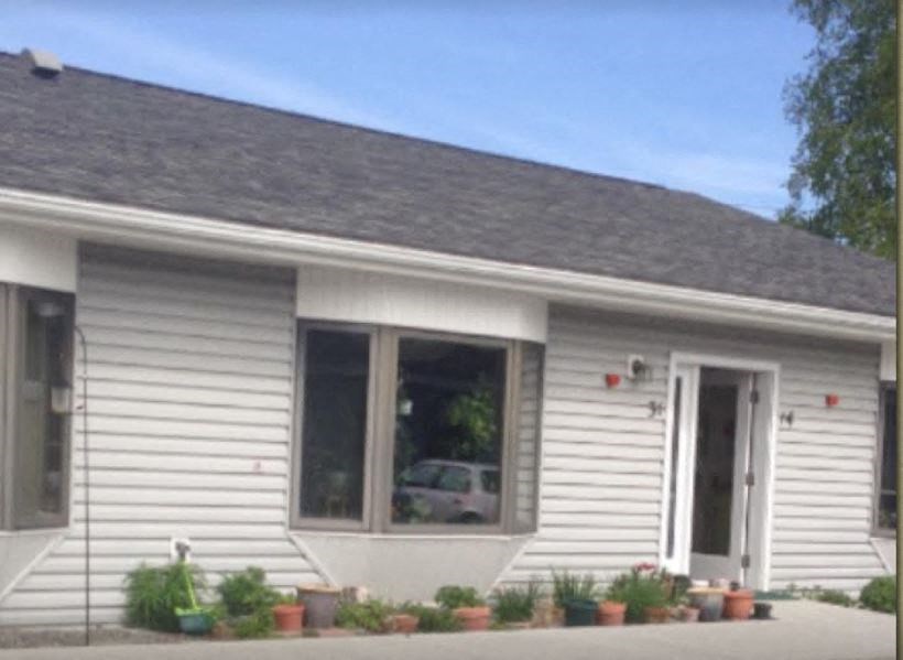the front of a white house with a large window