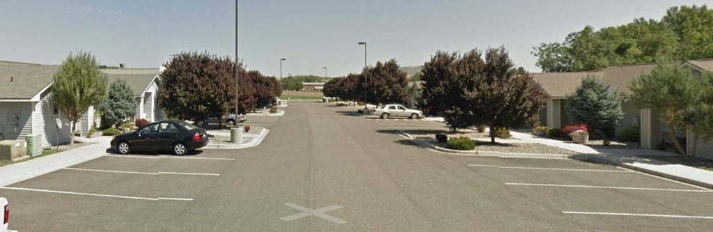 a city street with cars parked in a parking lot