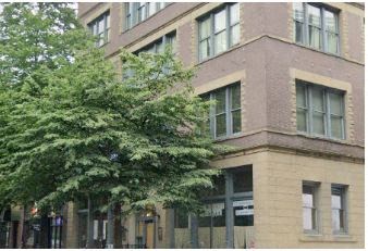 a large brick building with a tree in front of it