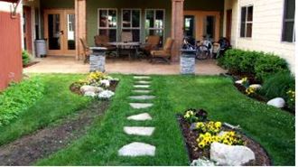 a yard with a stepping stone path leading to a patio