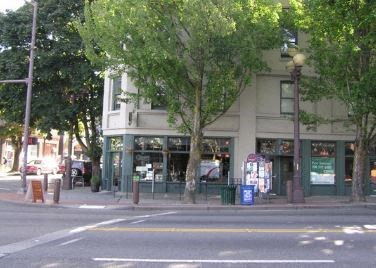 a building on the corner of a street with trees