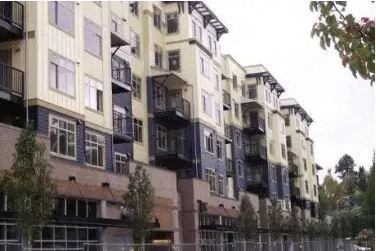 a building with many balconies and a fence in front of it