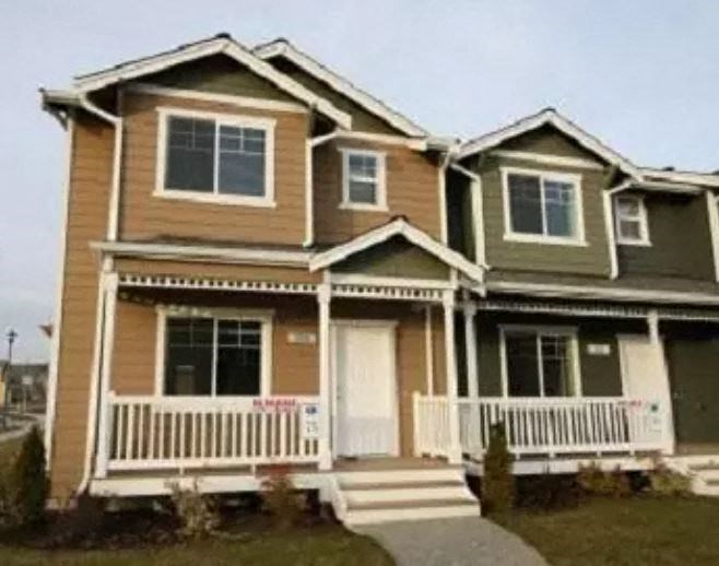 a brown house with a white porch and