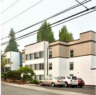 an apartment building with cars parked in front of it