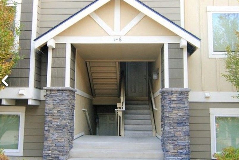 the front of a house with stairs and a door
