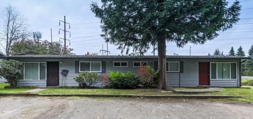 a white house with a tree in front of it