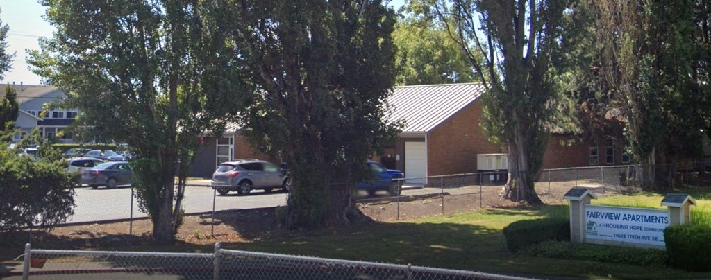 a building with a sign in front of it and some trees