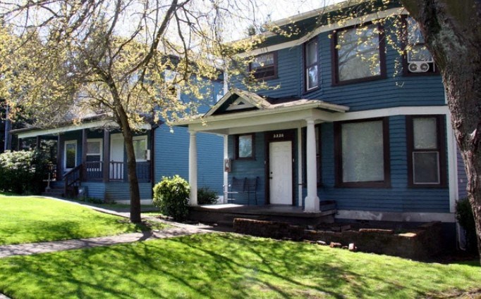 A blue house with a white door and windows.