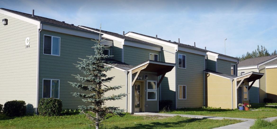 a row of houses with green and yellow roofs