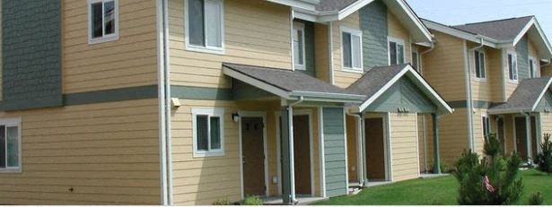 a row of houses with yellow and green siding