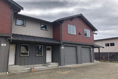 a red and white house with gray garage doors