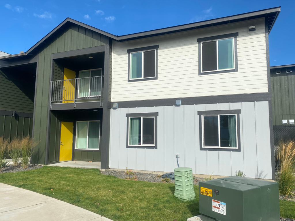 a white and gray house with a yellow door